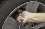 Hand Filling Air Into A Car Tire, Close Up Stock Photo