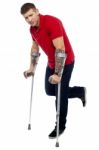 Young Guy Walking With Crutches Stock Photo