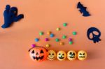 Halloween Jack O Lantern Bucket With Candy On Orange Background, Stock Photo