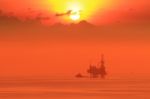 Silhouette Of Offshore Jack Up Drilling Rig And Boat Stock Photo