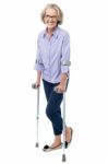 Bespectacled Old Woman Walking With Crutches Stock Photo