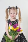 Happy Blonde Little Girl With Tulips Stock Photo