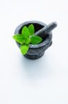 Stone Mortar And Pestle With Peppermint Leaf On White Wooden Bac Stock Photo