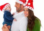 Happy Parents With Baby Boy Wearing Santa Hats Stock Photo