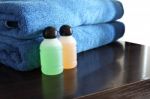 Spa Bottles And Blue Towel On Wooden Table Stock Photo