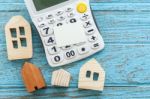 Calculator And Wood Houses On Wood Background Stock Photo