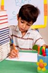 Young Kid Busy In Drawing Stock Photo