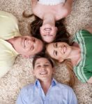 Happy Family Lying  With Their Heads Close Together Smiling Stock Photo