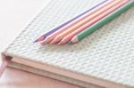 Closeup Colorful Pencils On Green Notebook Stock Photo
