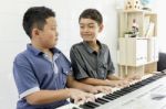 Friends Play Piano Together Stock Photo