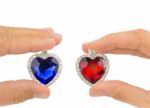 Fingers Holding Blue And Red Jewelry Hearts Stock Photo