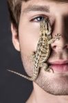 Portrait Of A Young Handsome Man With Lizard On His Face Stock Photo
