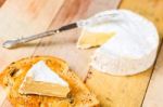 Camembert Cheese With Cut Wedge On Toasted Bread Slice And Vinta Stock Photo