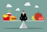 Man Balancing Between Junk Food And Healthy Food Stock Photo