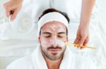 Man With Clay Facial Mask In Beauty Spa Stock Photo