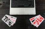 Bingo Cards And A Laptopo On Wooden Background Stock Photo