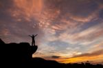 Silhouette Of A Man On The Rock At Sunset Stock Photo
