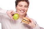 Chubby Man Holding Apple And Hamburger Stock Photo