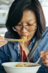 Women Eating Egg Noodle With Crispy Pork From Chopsticks And Met Stock Photo