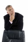 Thinking Businessman leant on Chair Stock Photo
