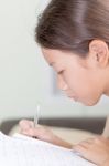 Asian Girl Writing On Lesson Book Stock Photo