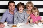 Family Of Four Having Great Time In Restaurant Stock Photo