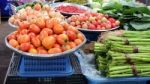 Baskets Of Tomatoes And Vegetable At A Farmer's Market Stock Photo