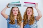 Two Schoolgirls With Textbooks On Their Head Stock Photo