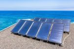 Rows Of Solar Collectors On Roof At Sea Stock Photo