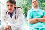 Serious Female Doctor With Colleague In Hospital Stock Photo