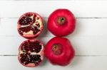 Fresh Pomegranate Fruits Isolated On A White Wooden Background Stock Photo