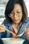 Women Eating Egg Noodle With Crispy Pork From Chopsticks And Met Stock Photo
