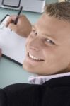 Smiling Ceo Writing on clipboard Stock Photo