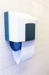 Towel Dispenser Hanging At Tiled Wall Stock Photo