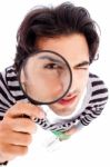 Young Man Looking Up With A Magnifying Glass Stock Photo