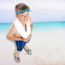 Smiling Boy Standing On Beach Background