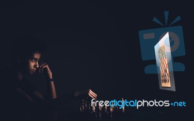 A Boy Playing Chess Against A Computer Stock Photo