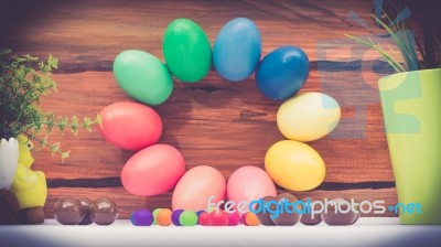 A Few Colorful Easter Eggs As A Flower Shape With Candies And Chocolate And Garden Plants Over Wood Background Happy Easter Stock Photo