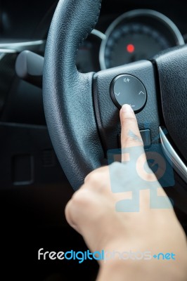 A Woman Hand Pushes The Volume Control Button On A Steering Wheel Stock Photo