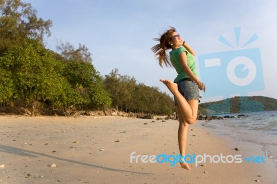 A Woman Jumping On A Beach Stock Photo