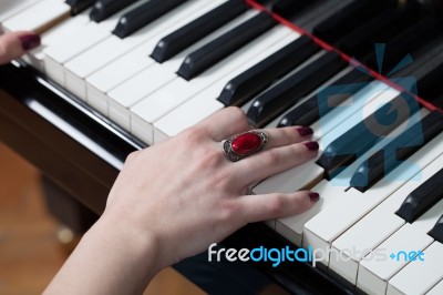 A Woman With Red Ring Playing Piano Stock Photo