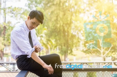 A Young Businessman Is Folding A White Sleeve On His Balcony Stock Photo