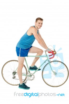 A Young Male Bicyclist Riding A Bicycle Stock Photo