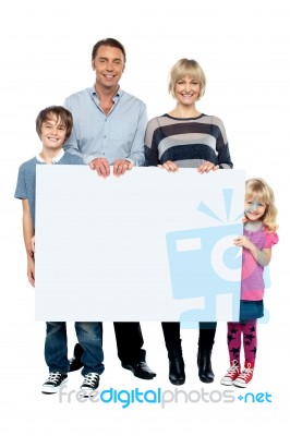 Active Young Family Displaying Blank Ad Board Stock Photo