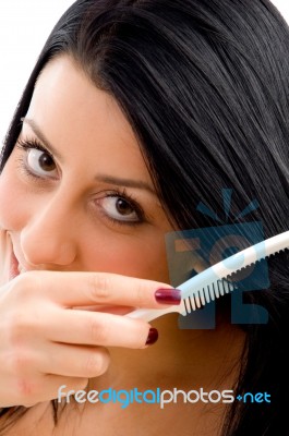 Adult Woman Combing Her Hair On An Isolated White Background Stock Photo