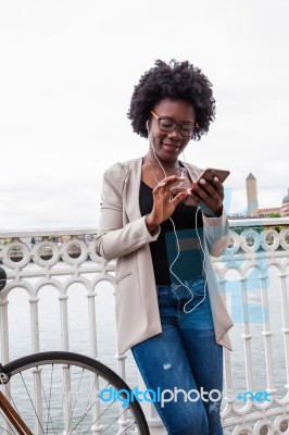 African Woman With Her Smartphone Listening Music Stock Photo