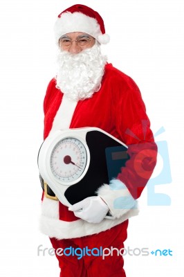 Aged Male Santa Holding Weighing Scale Stock Photo