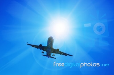 Airplane And Sunbeam With Lens Flare Effect On Blue Sky Backgrou… Stock Photo