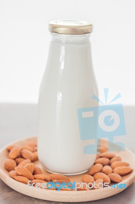 Almond Nuts On Wooden Plate With Milk Stock Photo