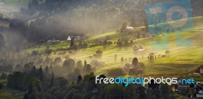 Alpine Village In Mountains. Smoke And Haze Over Hills Stock Photo